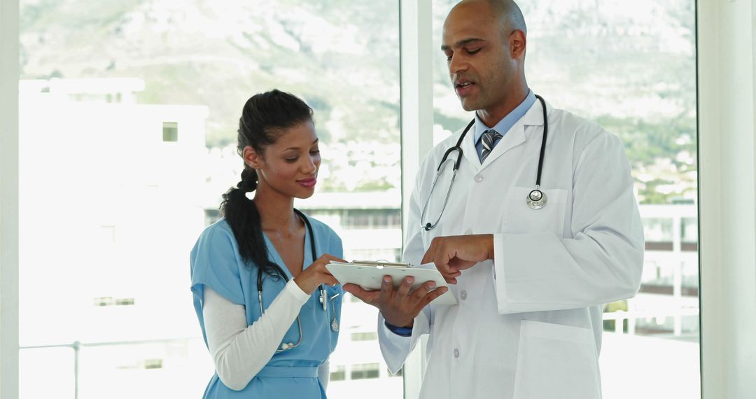 Doctor Discussing Medical Records with Nurse in Modern Hospital - Free Images, Stock Photos and Pictures on Pikwizard.com