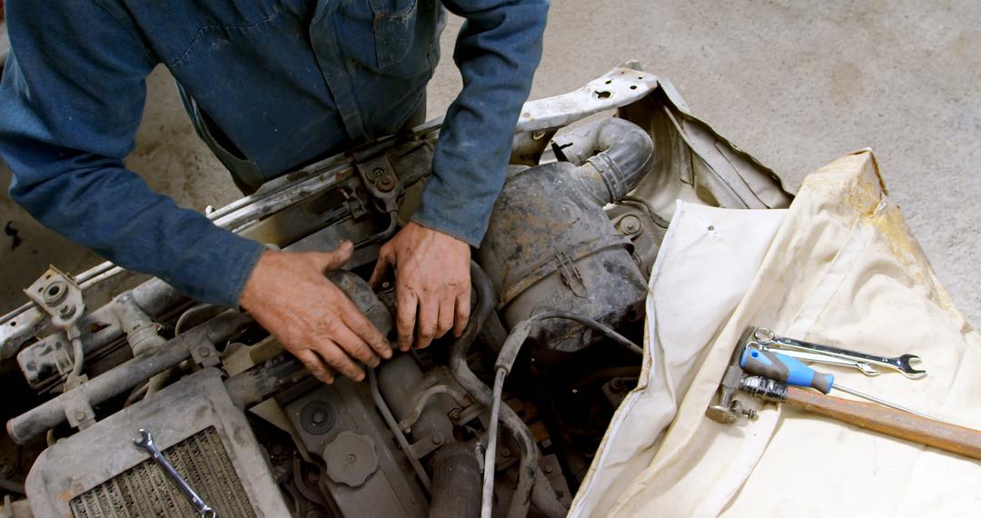 Mechanic repairing engine of worn-out vehicle - Free Images, Stock Photos and Pictures on Pikwizard.com