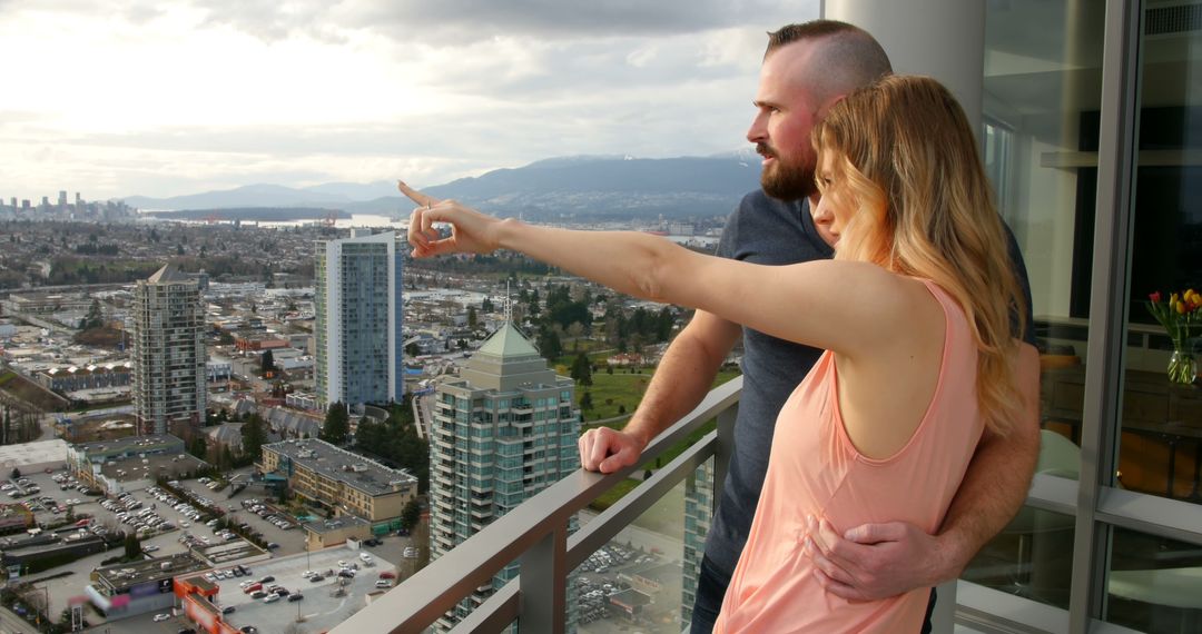 Couple Enjoying Urban View from Highrise Balcony - Free Images, Stock Photos and Pictures on Pikwizard.com