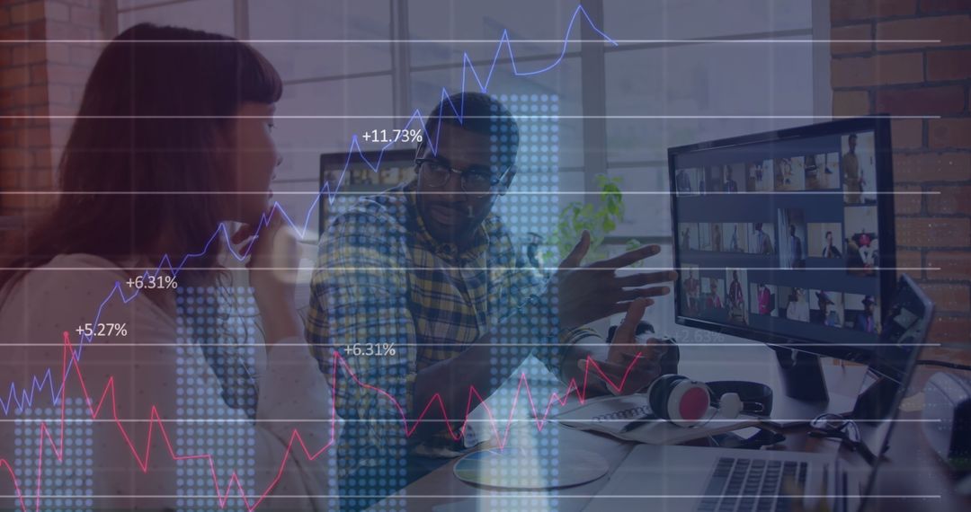 Coworkers Analyzing Data Trends in Modern Workspace