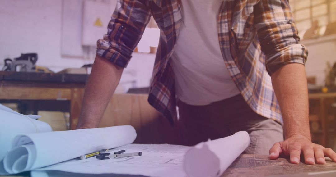 Architect Analyzing Blueprints for Construction Project in Workshop