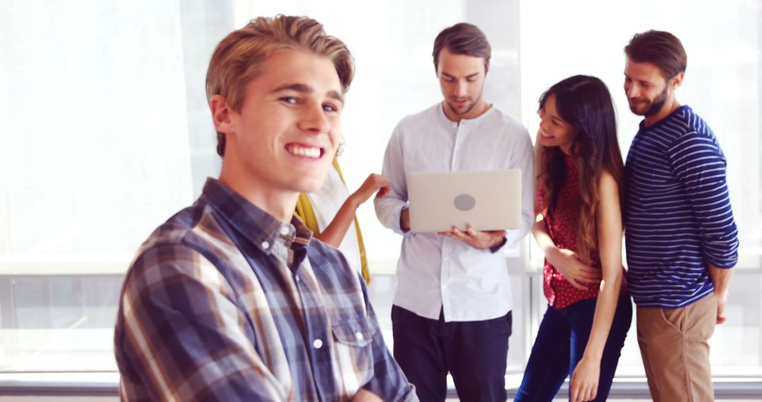 Young Professional Smiling with Collaborative Colleagues in Background