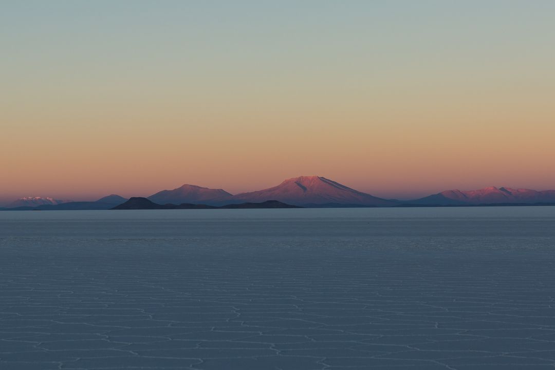 Dawn Light Illuminating Mountain Range Over Salt Flats - Free Images, Stock Photos and Pictures on Pikwizard.com
