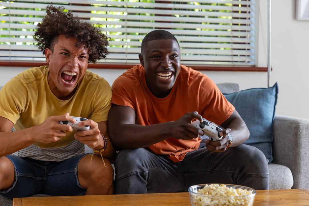 Diverse Friends Enjoying Video Gaming on Sofa with Snacks