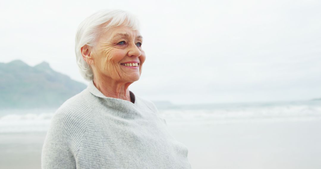 Happy Elderly Woman Enjoying a Day at the Beach - Free Images, Stock Photos and Pictures on Pikwizard.com