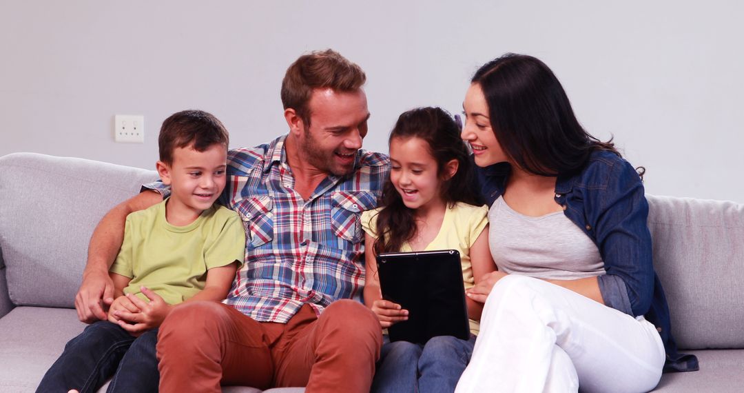 Happy Family Sharing Tablet Together on Sofa at Home - Free Images, Stock Photos and Pictures on Pikwizard.com