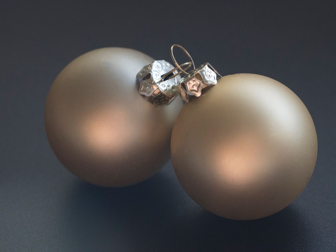 Pair of Elegant Metallic Christmas Baubles on Dark Surface
