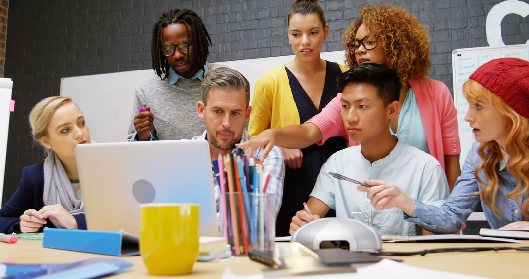 Diverse Team Brainstorming Around Computer in Modern Office