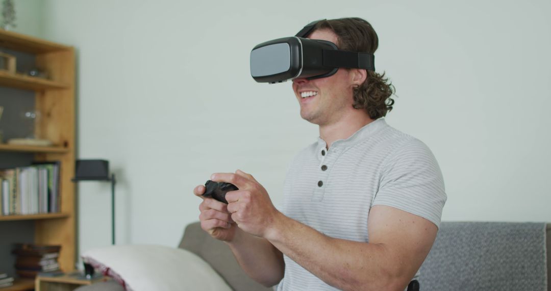Smiling Man with Virtual Reality Headset Playing Game on Couch - Free Images, Stock Photos and Pictures on Pikwizard.com