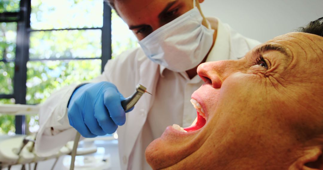 Dentist Treating Patient with Dental Drill - Free Images, Stock Photos and Pictures on Pikwizard.com