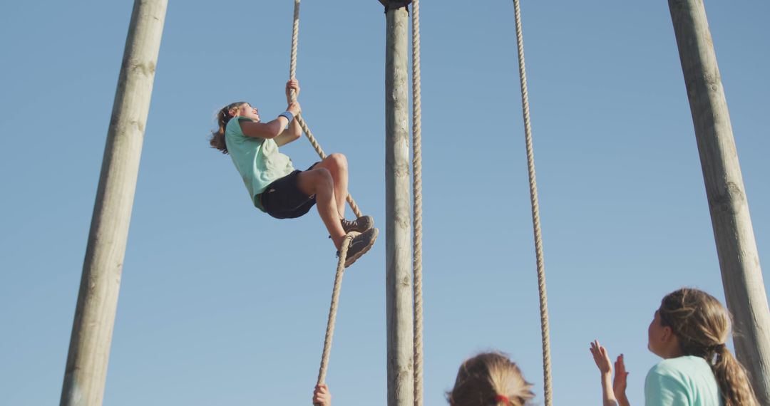 Supportive Friends Encouraging Boy Climbing Rope in Bootcamp Course - Free Images, Stock Photos and Pictures on Pikwizard.com