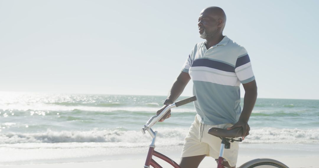 Senior African American Man Pushing Bike on Beach - Free Images, Stock Photos and Pictures on Pikwizard.com