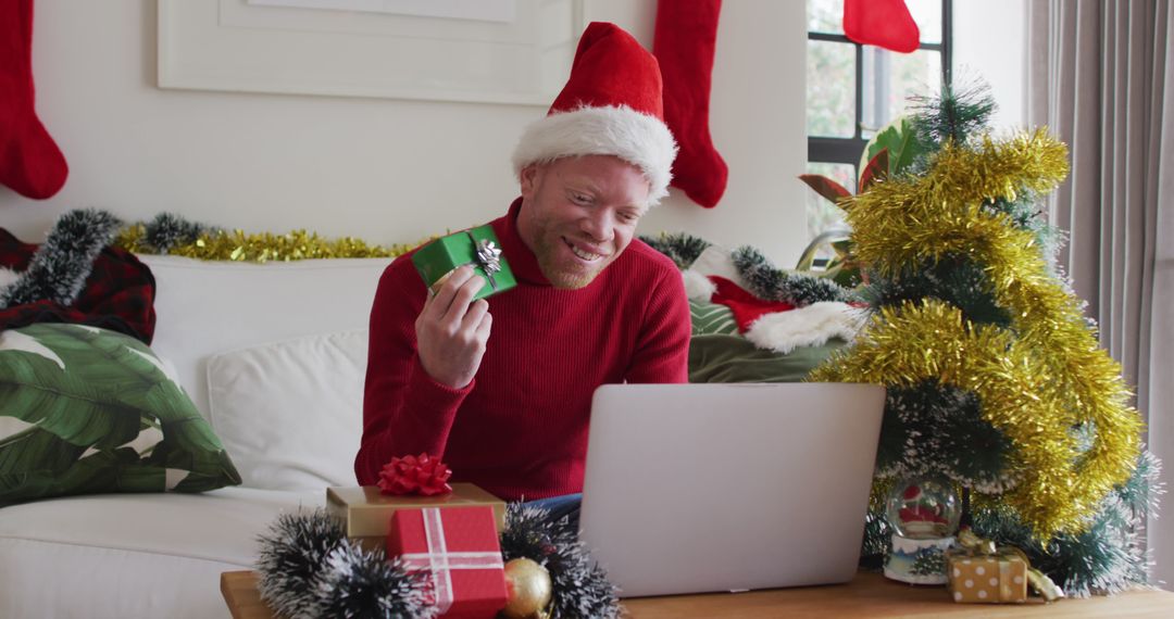 Man Holding Christmas Gift During Virtual Celebration at Home - Free Images, Stock Photos and Pictures on Pikwizard.com