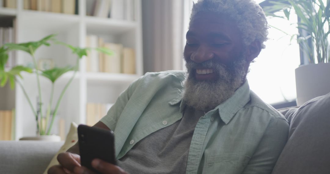 Smiling Senior Man Using Smartphone at Home - Free Images, Stock Photos and Pictures on Pikwizard.com