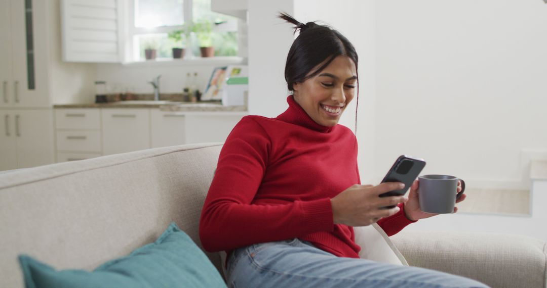 Smiling Woman Relaxing on Sofa with Smartphone and Coffee - Free Images, Stock Photos and Pictures on Pikwizard.com