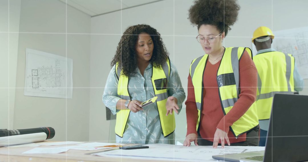 Diverse Engineers Collaborating on Building Blueprints