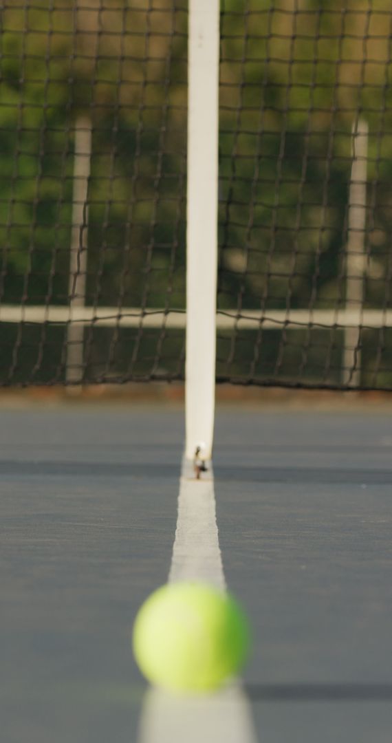 Close-Up of Tennis Court Net with Blurred Tennis Ball