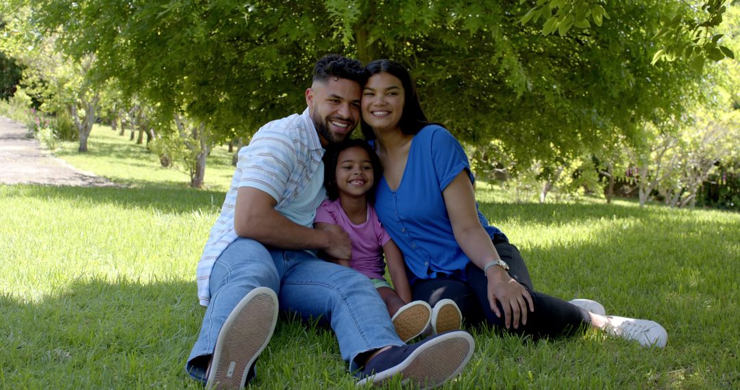 Happy Family Relaxing Outdoors Under Summer Tree