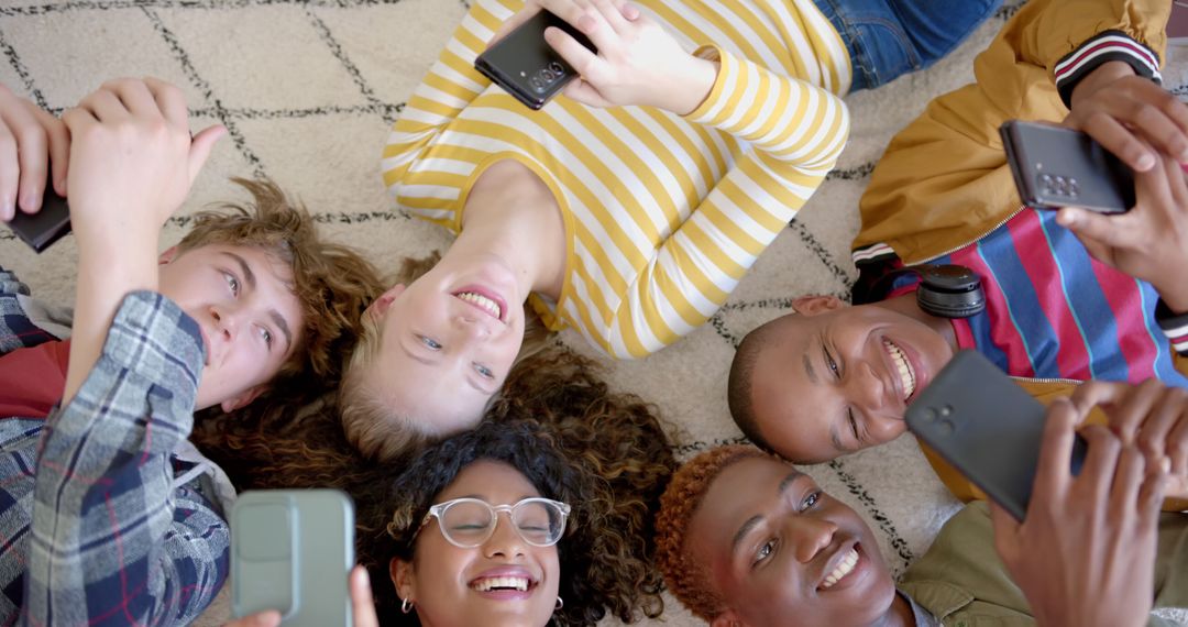 Diverse Friends Lying on Floor Enjoying Smartphone Social Media Together - Free Images, Stock Photos and Pictures on Pikwizard.com