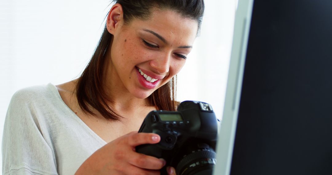 Smiling Woman Reviewing Photos on DSLR Camera Indoors - Free Images, Stock Photos and Pictures on Pikwizard.com