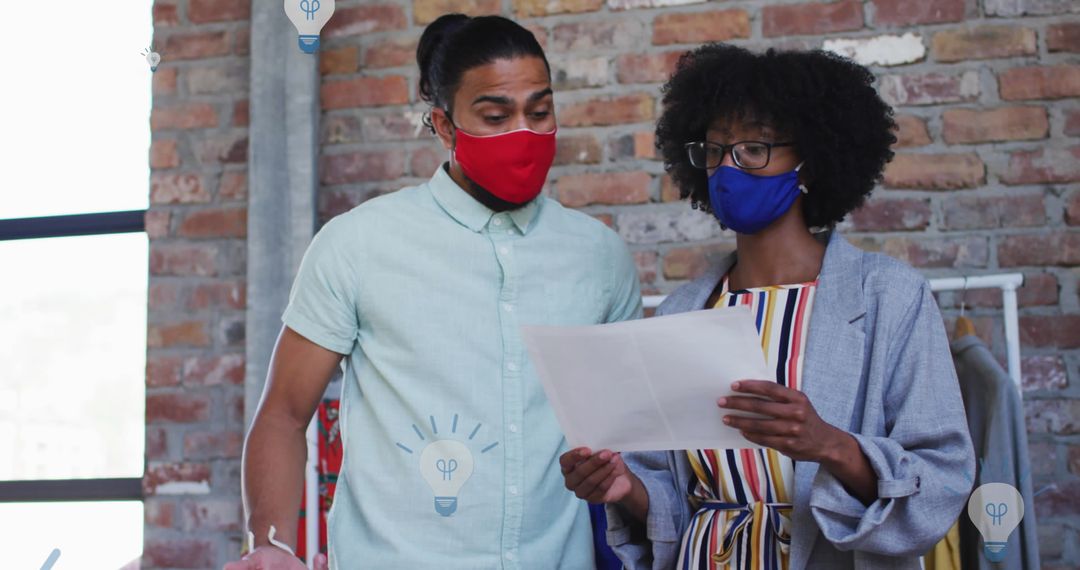 Colleagues Discussing Documents Wearing Masks in Modern Office