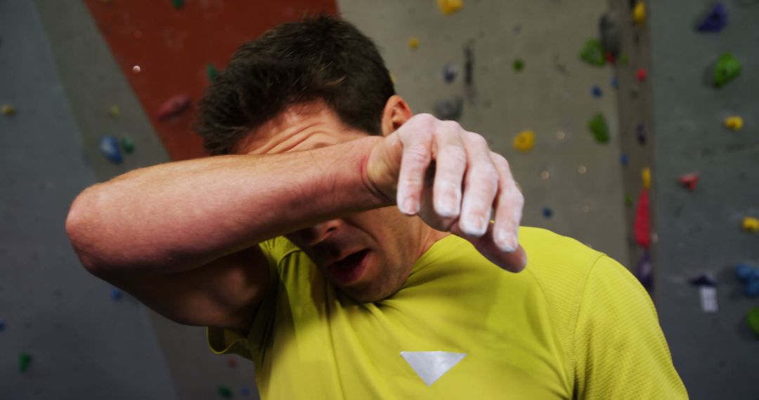 Tired Climber Wiping Sweat During Indoor Rock Climbing Exercise - Free Images, Stock Photos and Pictures on Pikwizard.com