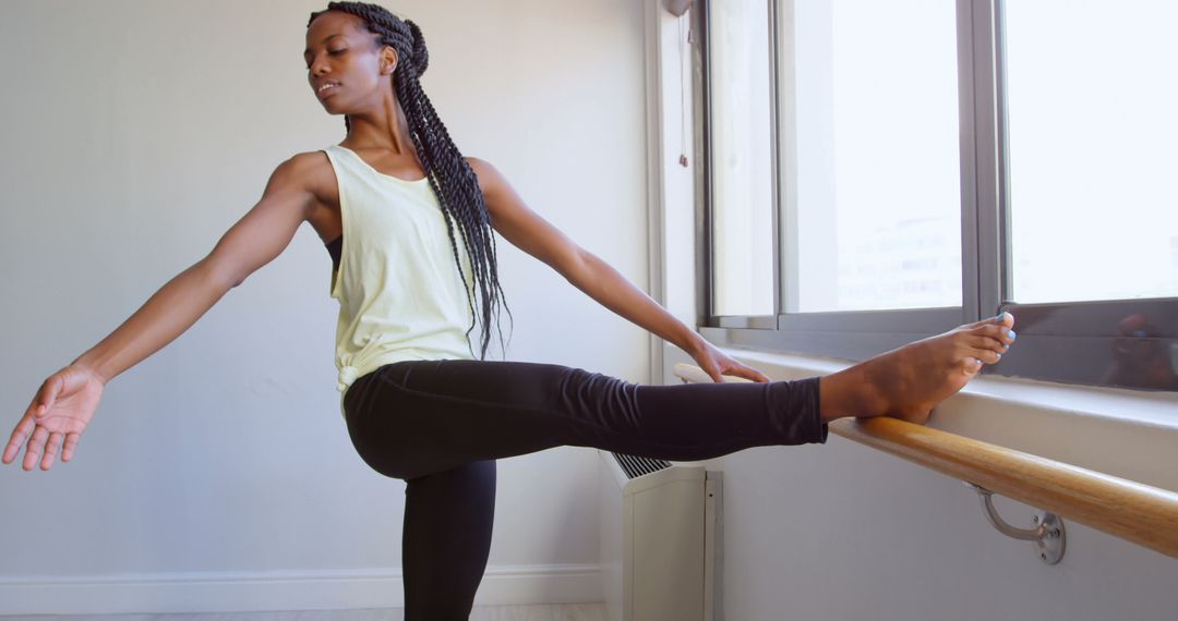 Dedicated Athlete Performing Stretching Routine by Gym Window