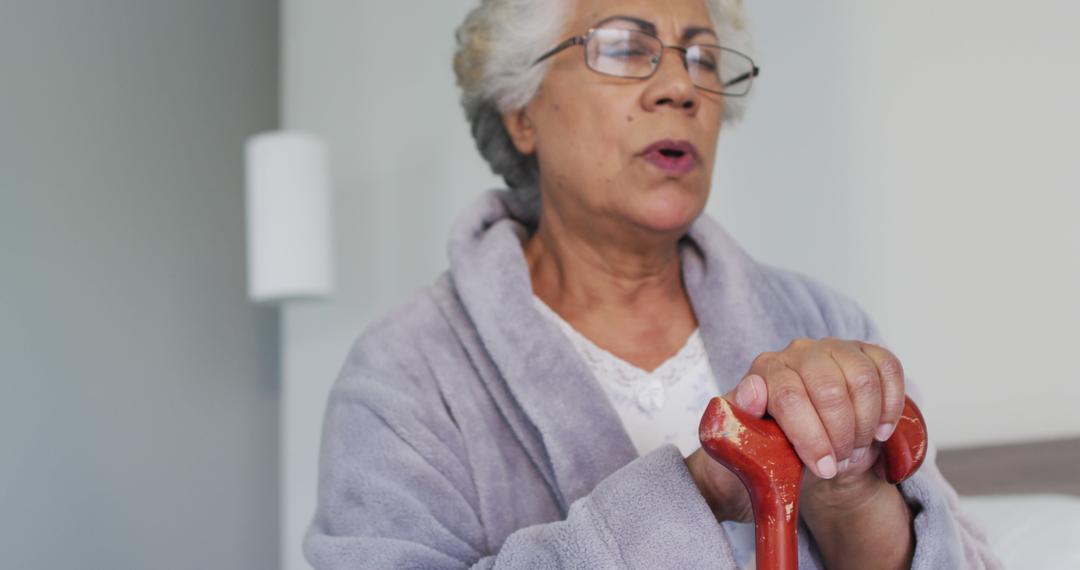 Elderly Woman Holding Walking Stick in Comforting Home Environment - Free Images, Stock Photos and Pictures on Pikwizard.com