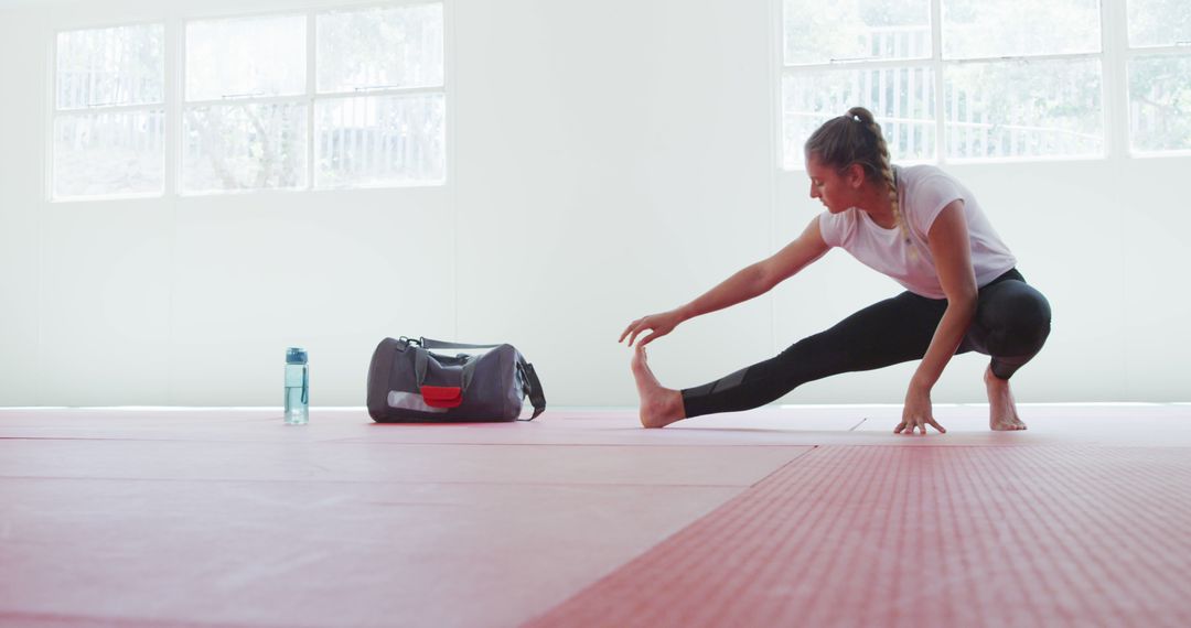 Woman Stretching on Exercise Mat in Minimal Studio - Free Images, Stock Photos and Pictures on Pikwizard.com