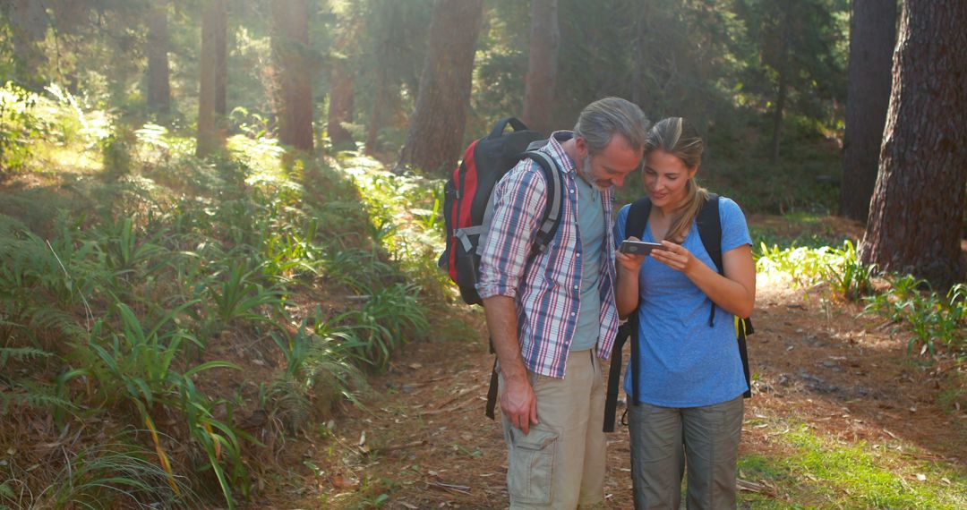 Happy Hikers Capturing Memories in Sunlit Forest