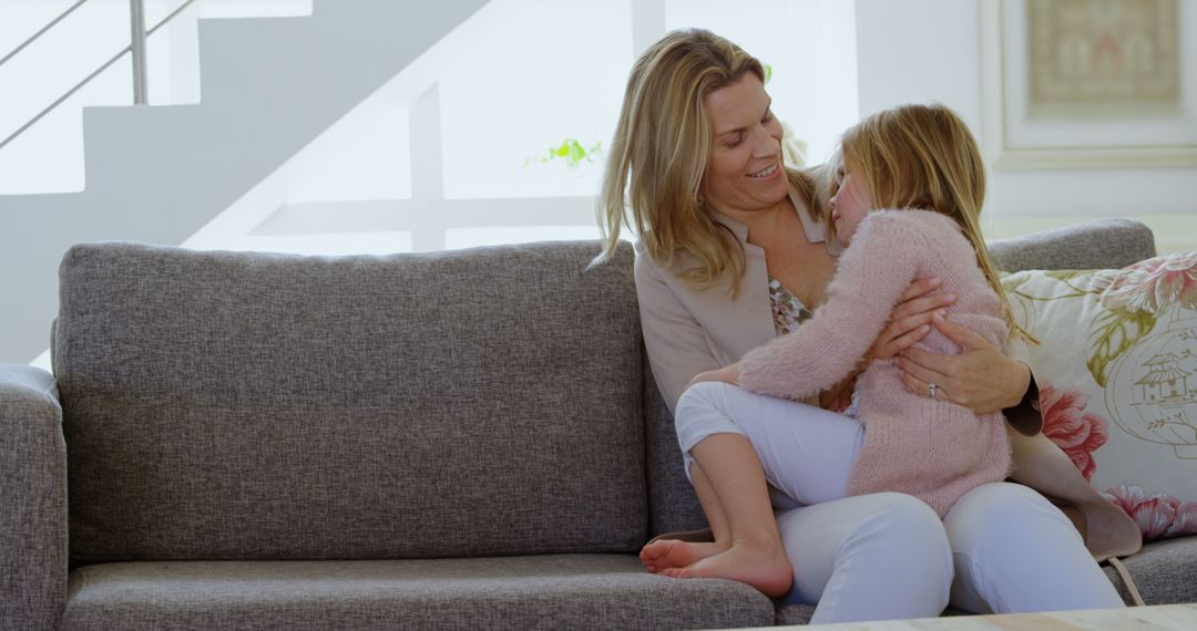 Loving Mother Embracing Daughter on Sofa at Home - Free Images, Stock Photos and Pictures on Pikwizard.com