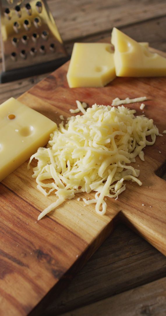 Grated Cheese and Blocks on Rustic Wooden Board