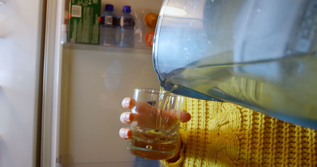 Person Pouring Water from Jug into Glass in Refrigerator - Free Images, Stock Photos and Pictures on Pikwizard.com