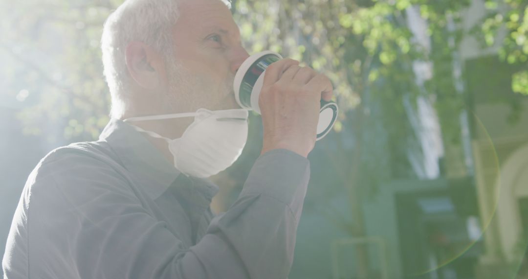 Senior Man Wearing Face Mask Drinking Coffee Outdoors on Sunny Day - Free Images, Stock Photos and Pictures on Pikwizard.com