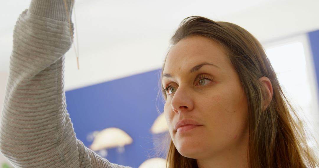 Woman Intently Looking at Object with Background Blurred - Free Images, Stock Photos and Pictures on Pikwizard.com