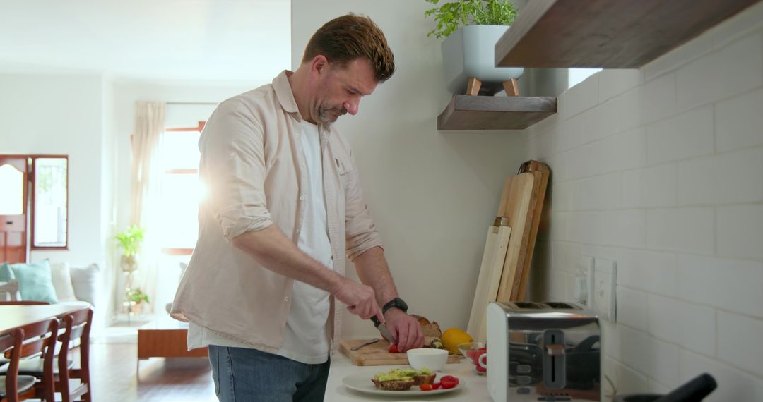 Man Slicing Tomato in Modern Kitchen for Avocado Toast