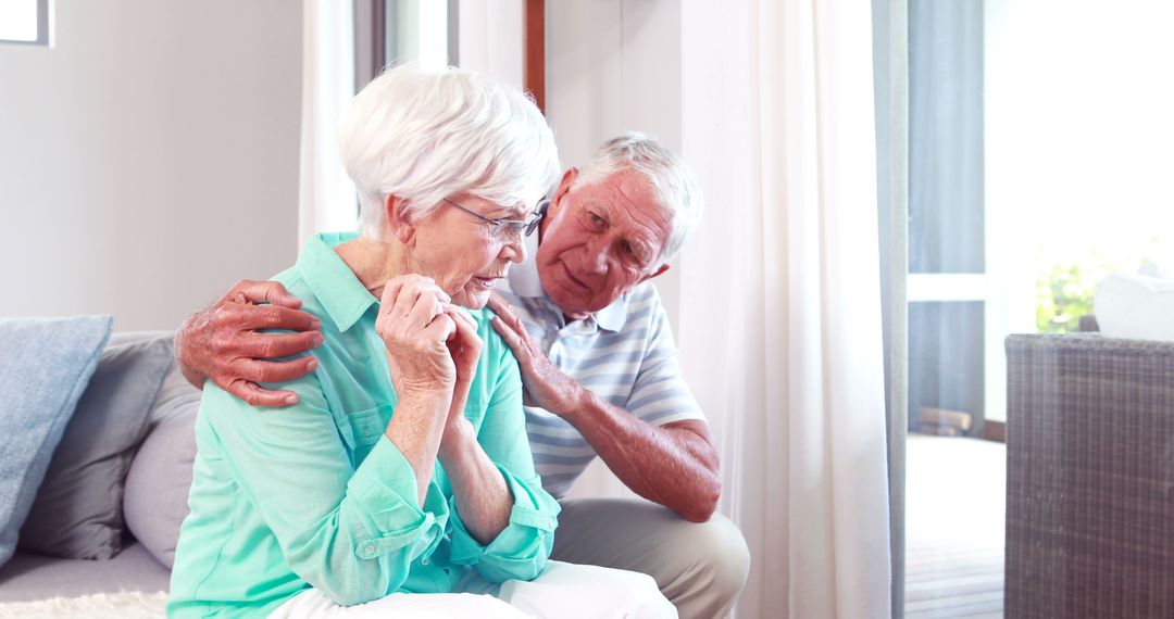 Caring Elderly Man Comforting Upset Elderly Woman Sitting in Living Room - Free Images, Stock Photos and Pictures on Pikwizard.com