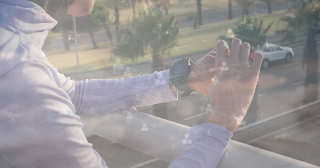 Person Using Smartwatch Overlooking Urban Road Through Glass - Free Images, Stock Photos and Pictures on Pikwizard.com