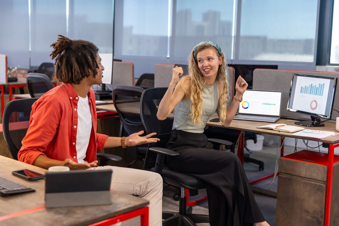 Diverse Coworkers Celebrating Success Analyzing Chart Data in Modern Office