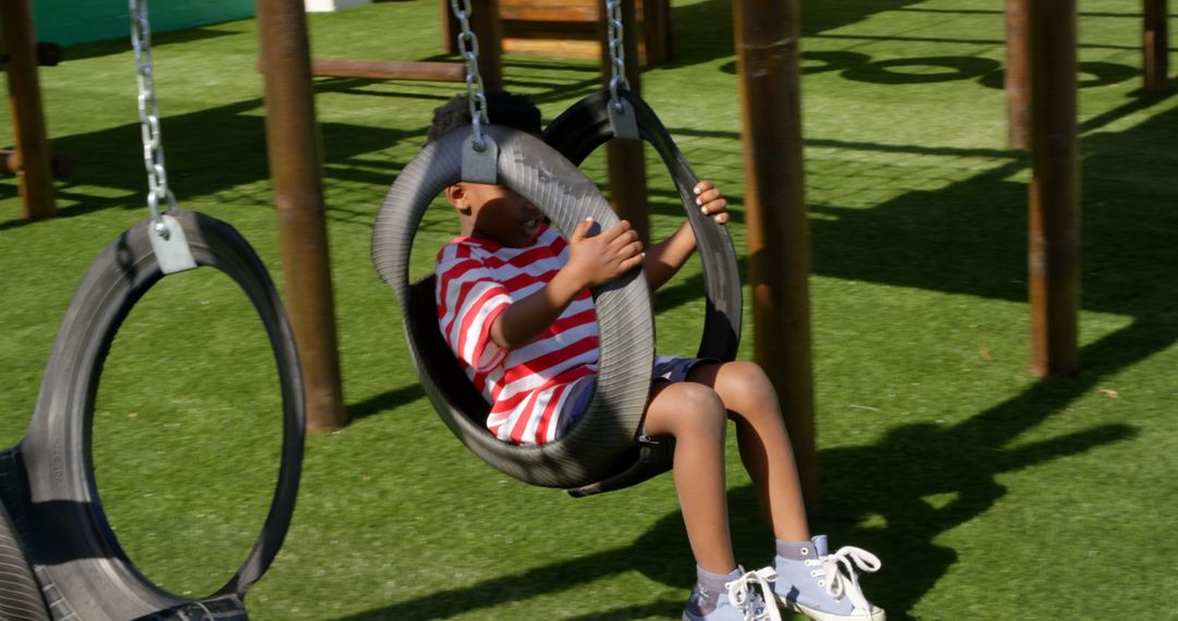 African American Boy Enjoys Playground Swing