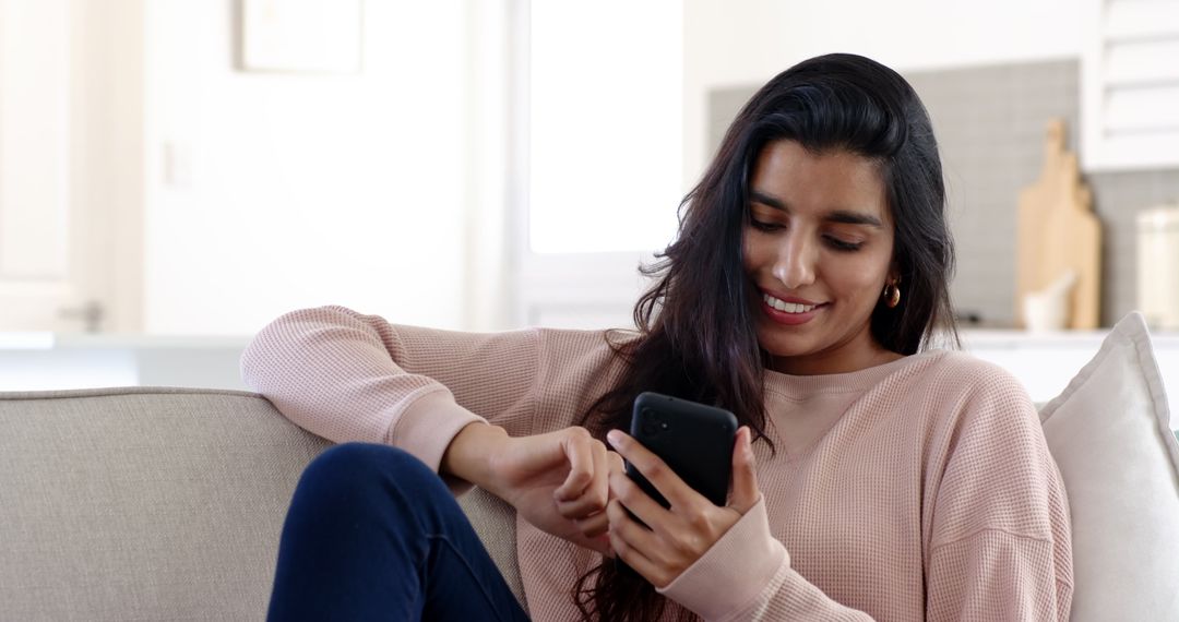 Smiling Woman Relaxing on Sofa Using Smartphone in Cozy Living Room