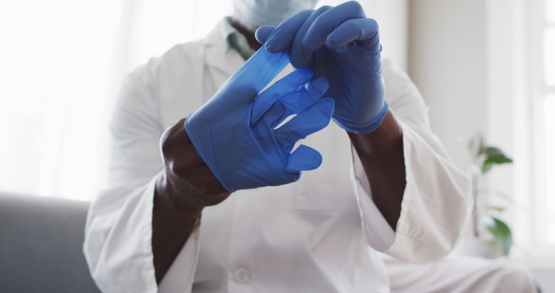 Medical Professional Putting on Protective Gloves in Clinic - Free Images, Stock Photos and Pictures on Pikwizard.com