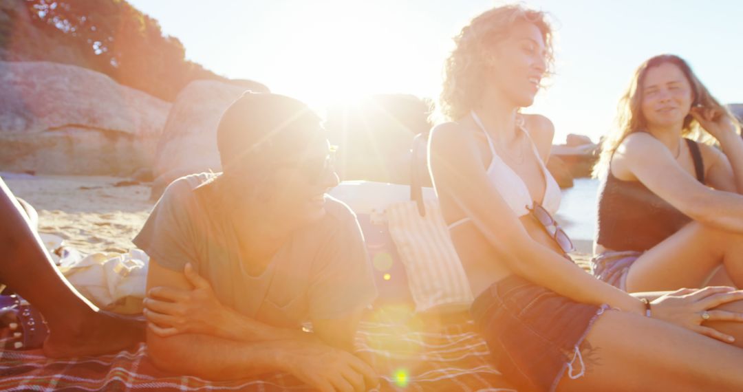 Group of Friends Relaxing on Beach at Sunset - Free Images, Stock Photos and Pictures on Pikwizard.com