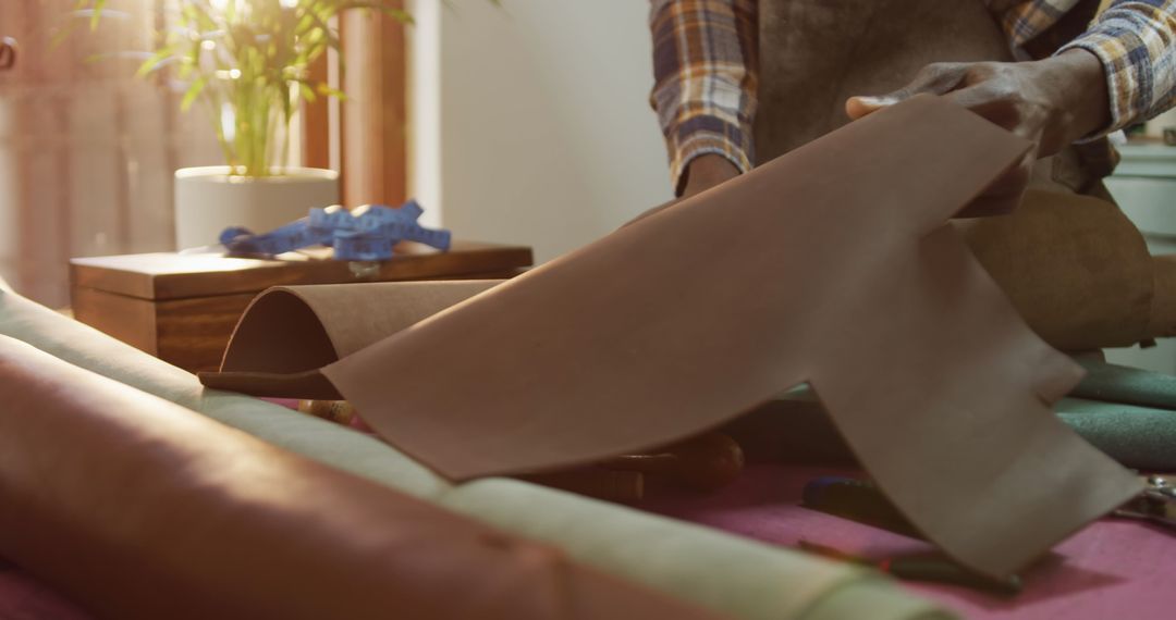 Craftsman Unrolling Leather in Artisan Workshop Space