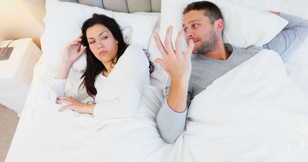 Caucasian Couple Arguing in Bed Expressing Frustration