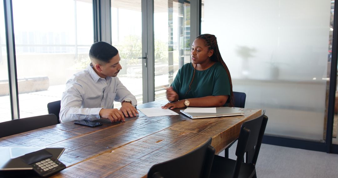 Diverse Professionals Discussing Business Contract in Modern Office