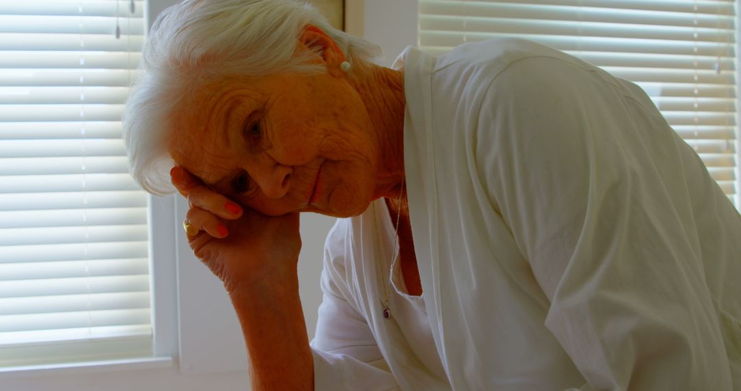 Elderly Woman Reflecting in Sunlit Room - Free Images, Stock Photos and Pictures on Pikwizard.com