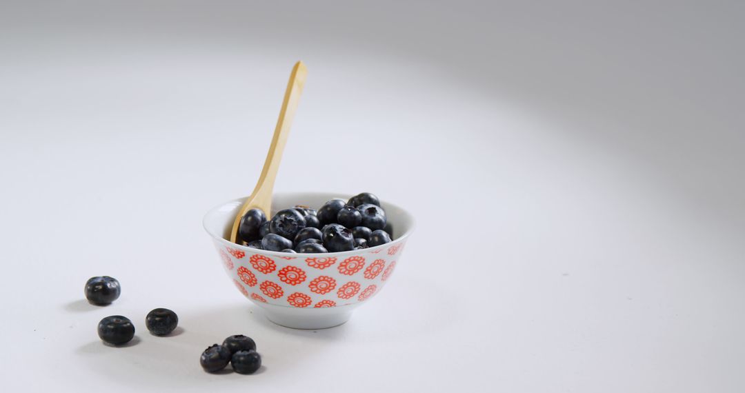 Fresh Blueberries in Decorative Bowl with Wooden Spoon on White Background - Free Images, Stock Photos and Pictures on Pikwizard.com