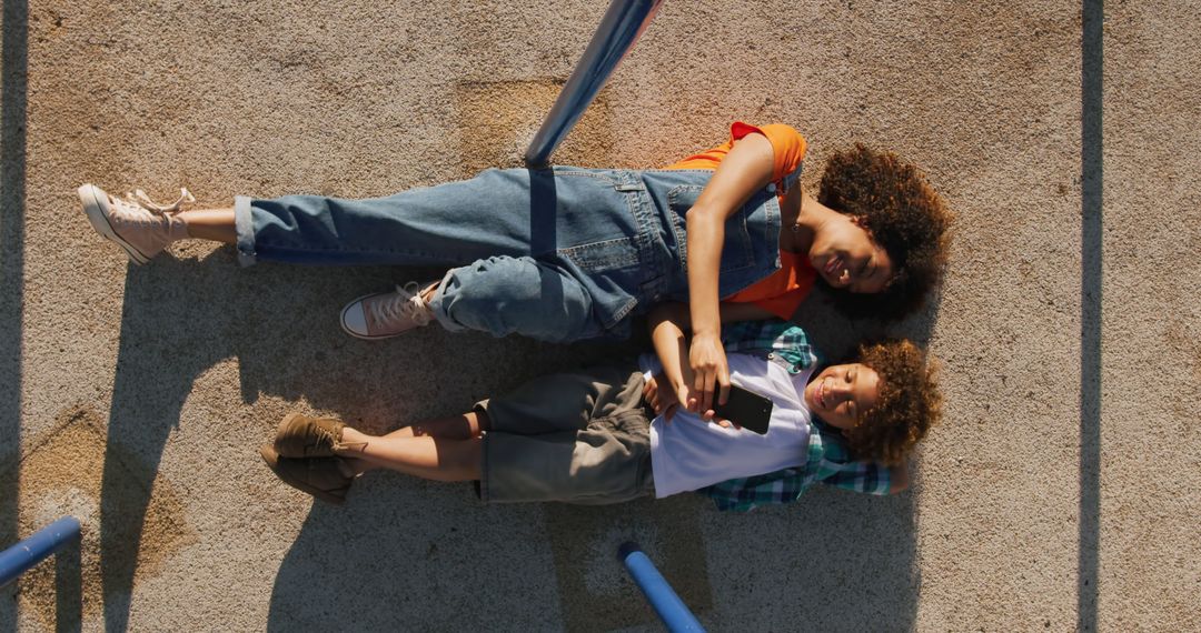 Outdoor Generation Z Siblings Enjoying Sunny Day Taking Selfie Relaxing on Ground - Free Images, Stock Photos and Pictures on Pikwizard.com