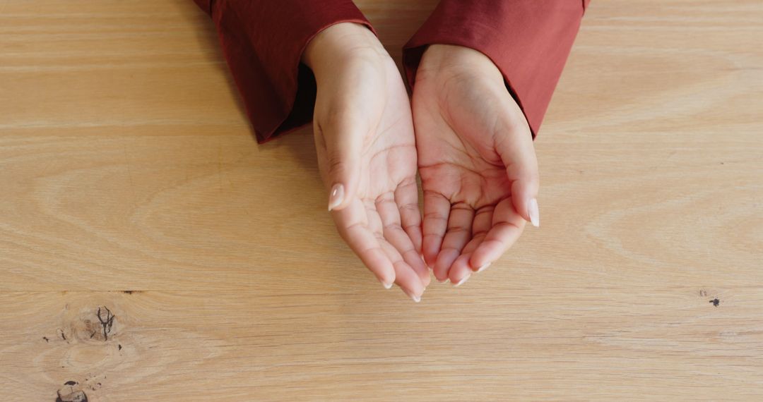 Open Hands Gesturing on Table Indicating Communication and Cooperation